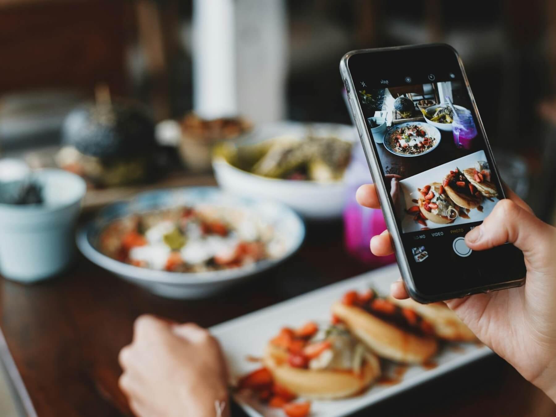 person taking a photo of food on a smartphone