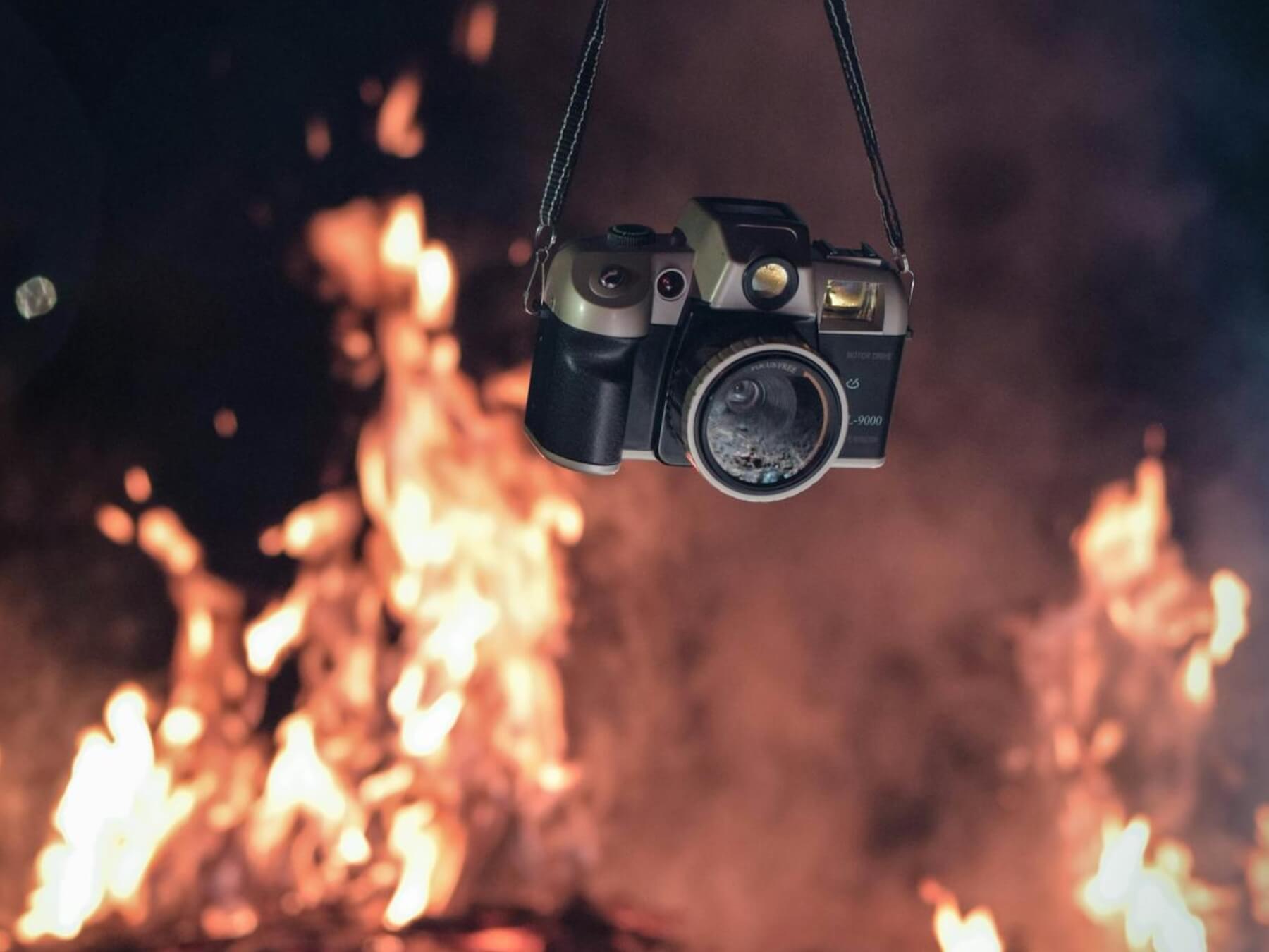 analog camera held near fire