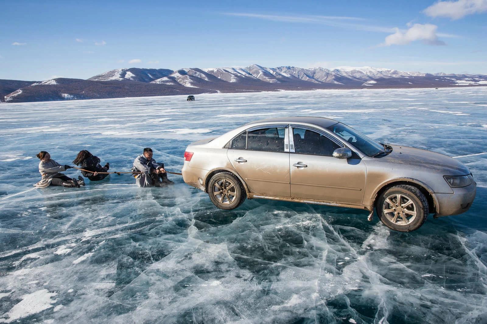 Friends are dragged by a rope attached to the back of a moving car near the Lake Khovsgol Ice Festival in Khatgal, Mongolia. Photo and story credits by Taylor Weidman.