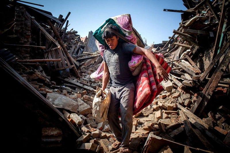 Earthquake victims carry out their belongings from damaged houses after a massive earthquake magnitude-7.8 hit the country In Bhaktapur, Kathmandu, Nepal May 01, 2015. The official death toll in Nepal has reached 7,500 people including 57 foreigners, with 112 foreigners still listed as missing says Interior Ministry spokesman Laxmi Dhakal. Another 10,915 people were injured and 454,769 have been internally displaced.