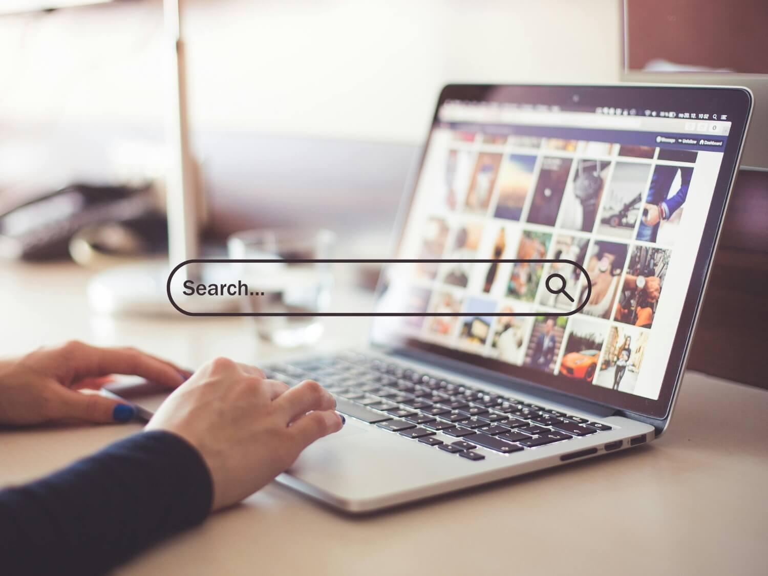 Woman on laptop with a search bar overlay.