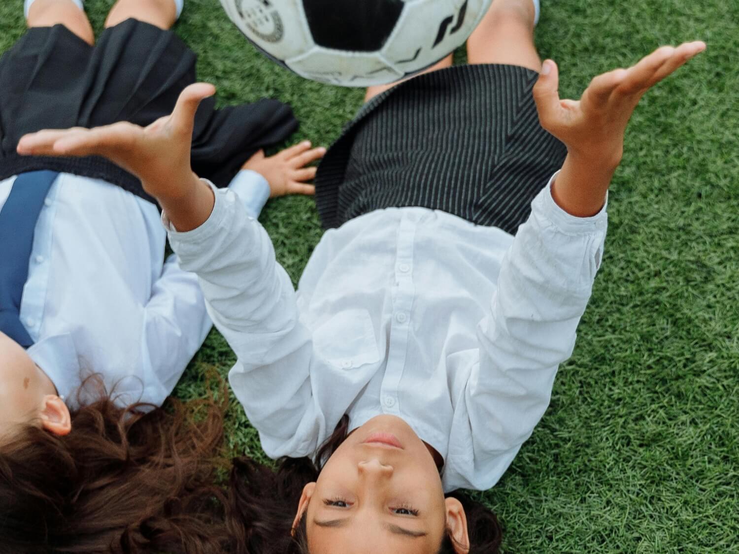 A girl in school uniform catching a ball.