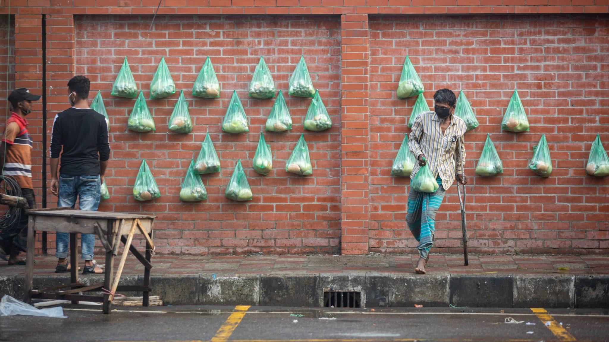 Members of the Bangladesh Civil Service Taxation Association keep relief material hung on a wall for the poor at Kakrail in the capital on Wednesday. The combo pack contains rice, lentil, potato, onion, salt and oil. Photo and story credits by Imtiaz Mahbub Mumit.