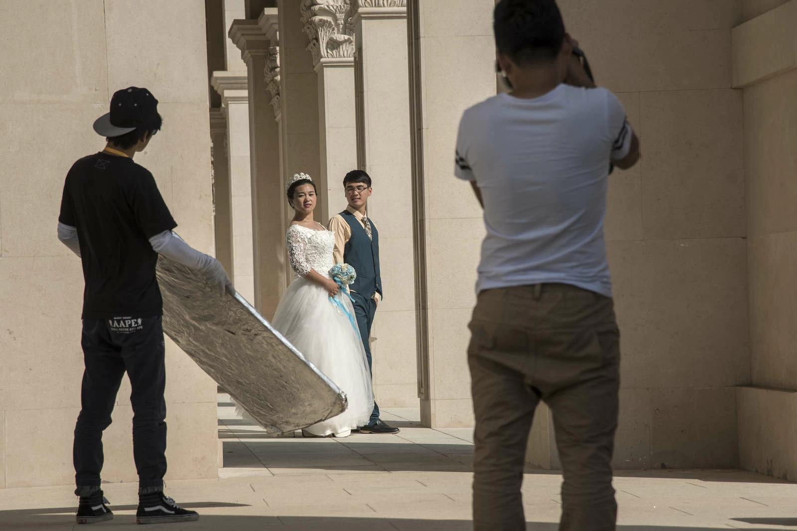 A couple in wedding dress poses for pictures in a archway at Dalian’s “City of Water”. The ?City of Water? also dubbed ?Venice of the East? or the ?Oriental Venice? is a large touristic project in Dalian?s Donggang business district stretching over 400,000 square meters with a replica of Venice and other European-style architecture buildings. Photo and story credits by Thierry Falise