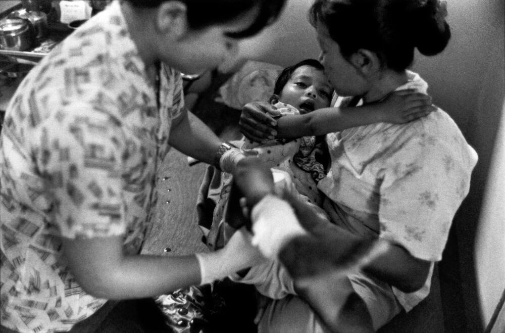 A young girl has her abscesses cleaned in Mae Tao clinic on the Thai side of the border. Even small cuts can become festering wounds and pose a threat to life. In Burma, lack of basic medicines and the collapse of a once-respectable healthcare system has created a medical emergency where even large hospitals are incapable of dealing with treatable conditions. July 2006.