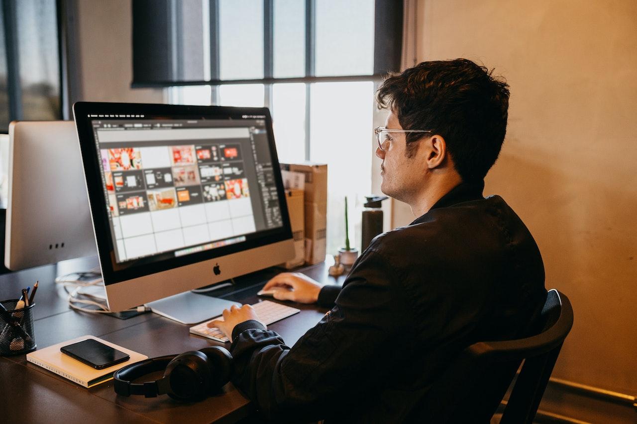 Man sitting at desk using a computer.