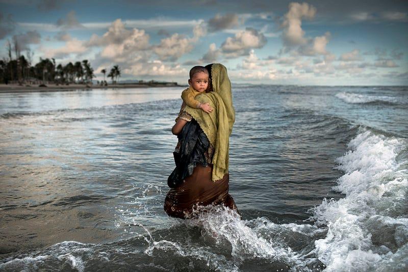 Myanmar Rohingya refugee woman holding her son after arriving on a boat to Bangladesh on Shah Porir Dip Island at Cox Bazar, 14 September 2017. According to UNHCR more than 646,000 Rohingya refugees have fled from Myanmar on August 25, 2017 most of them trying to cross the border to reach Bangladesh.