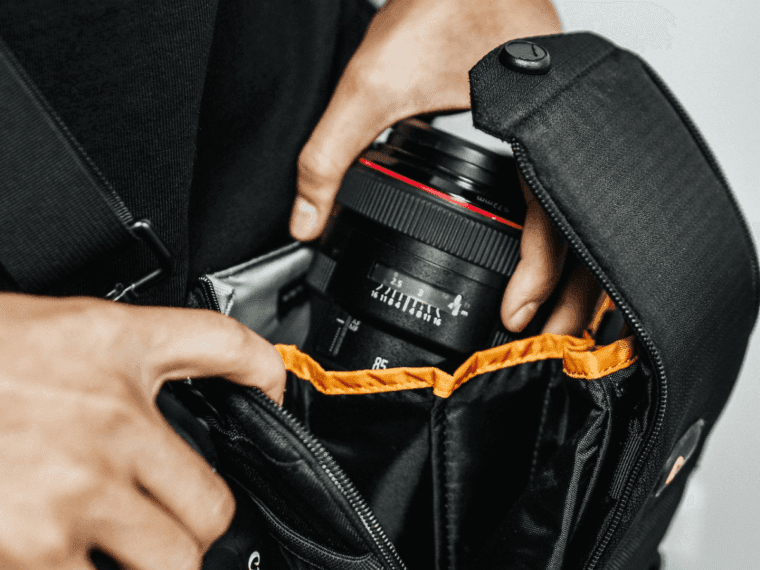 Removing camera lens from a bag.
