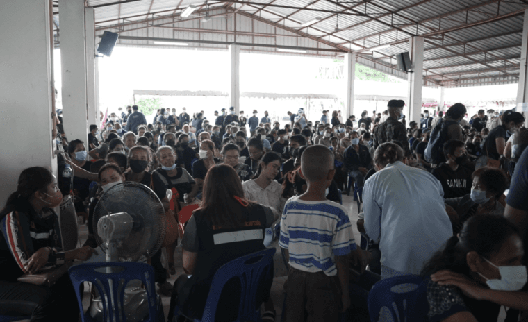 Parents and relatives gather under an open-sided shelter just opposite the day care center where the attack took place. Photo by Yvan Cohen