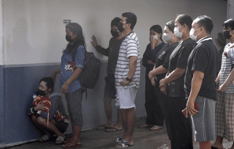 A woman hugs a blanket, weeping as she mourns her child who was among 24 childen killed by Panya Khamrab at a child care center in northeast Thailand. Photo by Yvan Cohen