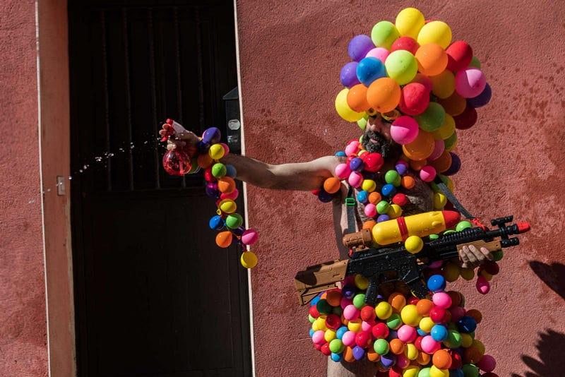 A reveler covered with balloons during the annual water fight known as “Batalla Naval” in Vallecas neighborhood, where thousands of people gathered to play with water. Photo and story credits by Marcos del Mazo.