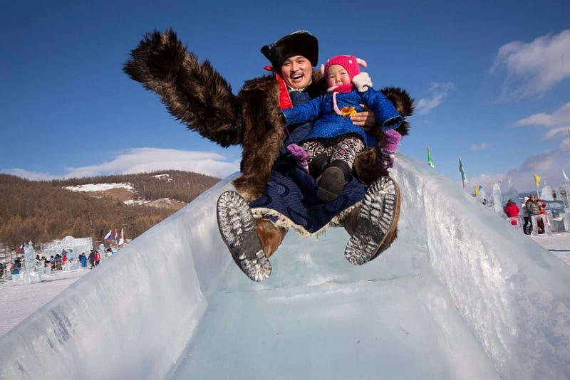 A Mongolian man and his child go down a slide at the Lake Khovsgol Ice Festival in Khatgal, Mongolia, on March 3, 2017. See more from photos from Taylor Weidman here.