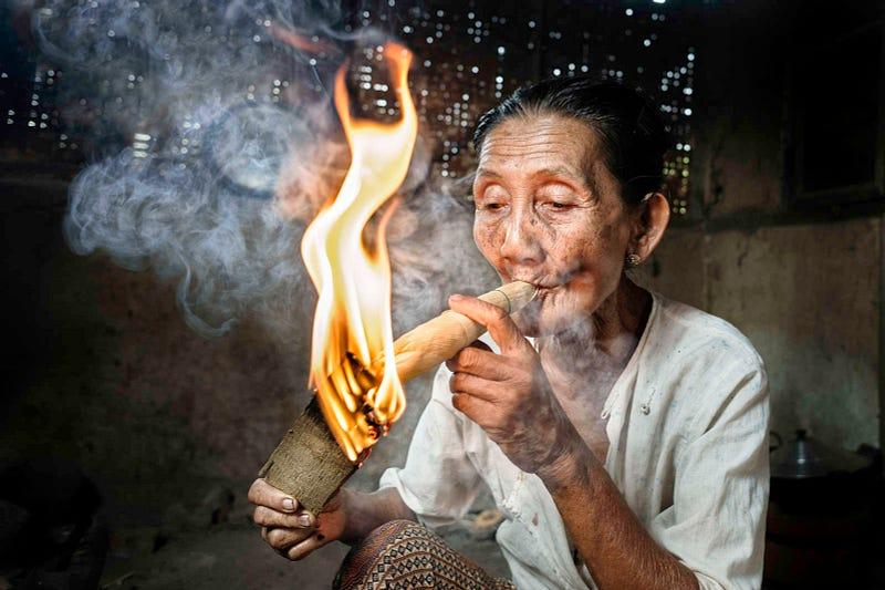 Woman smoking a big cigar made out of corn leaves and tobacco. See more images from Jorge Fernández Garcés here.